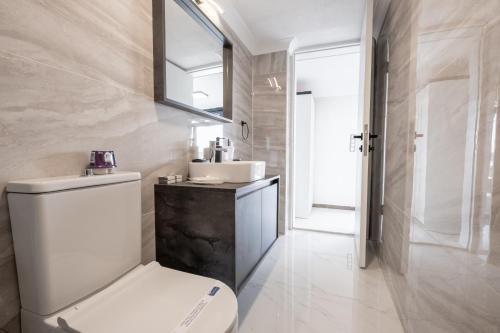 a bathroom with a white toilet and a sink at Select Cunda Guest House - Sea View Room with Private Veranda in Cunda Island in Ayvalık