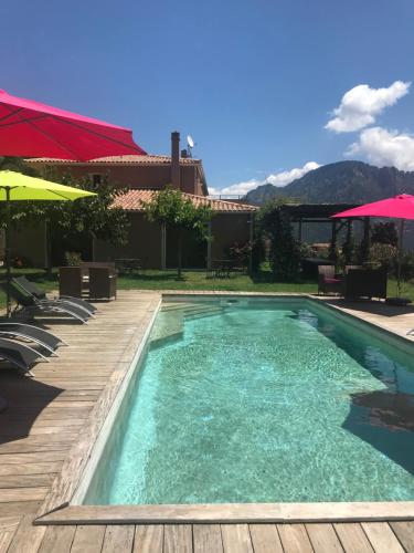 a swimming pool with a wooden deck and a swimming pool at Domaine U Bugnu in Vico