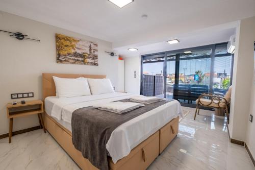 a bedroom with a large bed and a large window at Select Cunda Guest House - Sea View Room with Private Veranda in Cunda Island in Ayvalık