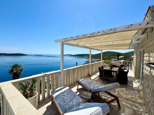 un patio con mesa, sillas y el océano en Apartment MORE Island Vis en Vis