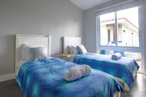 een slaapkamer met 2 bedden en een raam bij Villa #1 - Blue Venao, Playa Venao in Playa Venao