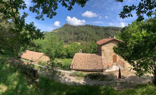 una casa en un campo con montañas al fondo en Mas en Cévennes - Brèç de l'anhel, la Jaça, en Saint-Paul-la-Coste