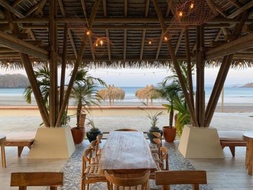 a table in a restaurant with a view of the beach at Villa #35 - Blue Venao, Playa Venao in Playa Venao