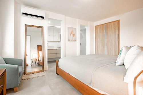 - une chambre avec un lit, une chaise et un miroir dans l'établissement Blue Venao CONDO APARTMENT C21, à Playa Venao