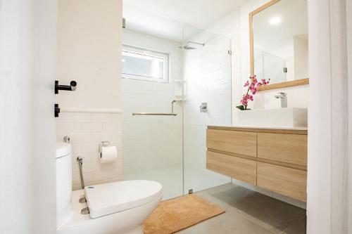 a white bathroom with a toilet and a sink at Blue Venao PENTHOUSE APARTMENT B in Playa Venao