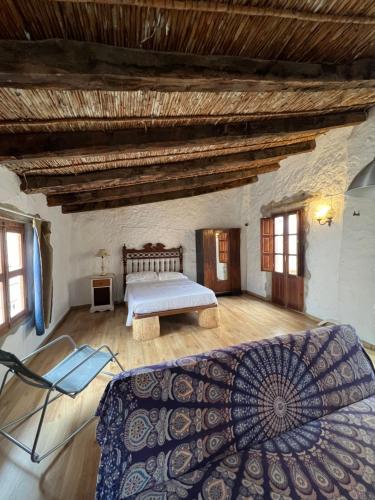 ein großes Schlafzimmer mit einem Bett und einer Holzdecke in der Unterkunft Casa Rural Única en Xàtiva in Xàtiva