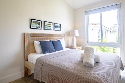 a bedroom with a bed with blue pillows and a window at Villa #7 - Blue Venao, Playa Venao in Playa Venao