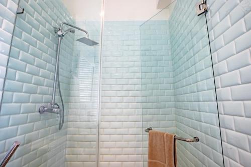 y baño con azulejos azules y blancos y ducha. en Villa #7 - Blue Venao, Playa Venao, en Playa Venao