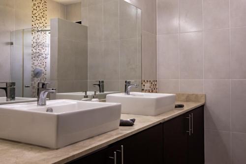ein Badezimmer mit zwei Waschbecken und einem großen Spiegel in der Unterkunft Super Private Beachfront 3BR Villa with Infinity Pool Andromeda Pedasi in Pedasí Town