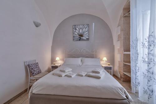 una camera con un letto bianco e due sedie di Borgo Diaz a Cisternino