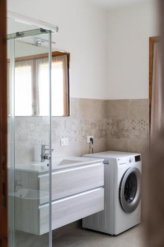 a bathroom with a washing machine and a sink at Mera House in Posada