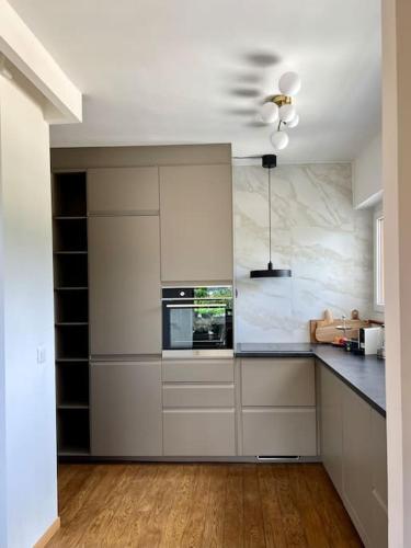 a kitchen with white cabinets and a stove top oven at Panorama Suite in Lugano - Pazzallo in Paradiso