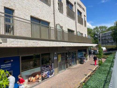 Ein Gebäude mit Leuten, die davor laufen. in der Unterkunft Centrally Located 2Bed Flat With Balcony & Parking in Cardiff