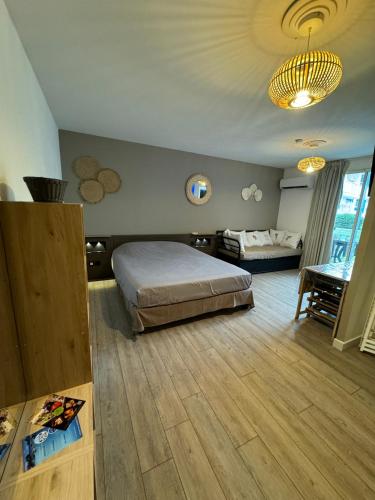 a bedroom with a bed and a table in a room at Coco and sun Hibiscus Le Manganao in Belle-Allée