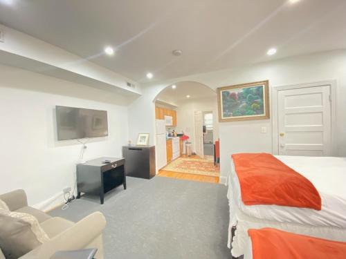 - une chambre avec un lit, une chaise et une télévision dans l'établissement Gorgeous Refurbished 1Bdrm and 1Den Home, à Washington