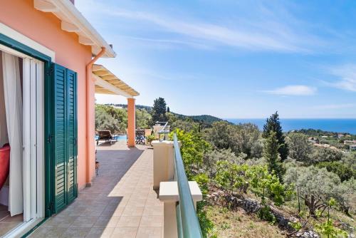 a balcony of a house with a view of the ocean at Villa Belvedere Rosa in Tsoukaladhes
