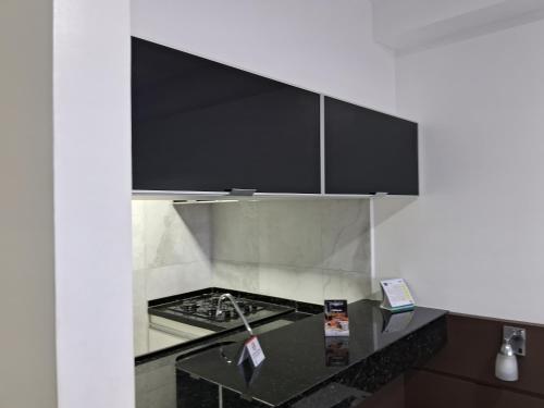 a kitchen with a black counter top and black cabinets at hotel tambau flat particular 605 in João Pessoa