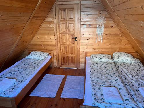 um quarto com 2 camas num chalé de madeira em Pokoje Gościnne Pod Brzozą em Władysławowo