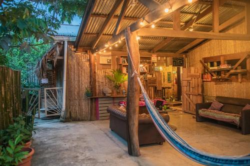 a room with a hammock in a house at Roots Family in Puerto Viejo