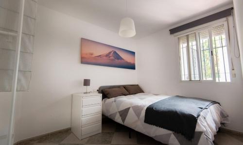 a bedroom with a bed and a picture on the wall at Mar y montaña in Monachil