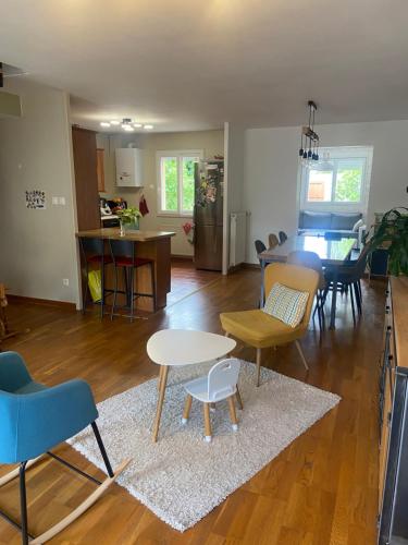 un salon avec une table et des chaises dans l'établissement maison proche du circuit des 24H, au Mans