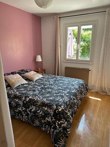 une chambre avec un lit et une fenêtre dans l'établissement maison proche du circuit des 24H, au Mans