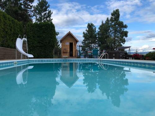 ウェストケロウナにあるHeated pool, hot tub, 4 AC lake view bedroomsの青いスイミングプール付きの大型スイミングプール