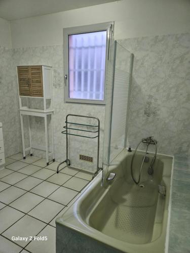 a bathroom with a bath tub and a window at Le temps d'une pause ! Petit-déjeuner inclus ! in Servas
