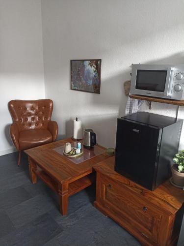 a living room with a television and a coffee table at Privates Gästezimmer in Altenburg in Altenburg