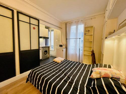 - une chambre avec un lit dans une pièce avec une cuisine dans l'établissement Studio Paris 15e G Tour Eiffel Roland Garros, à Paris