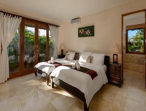 Un dormitorio con dos camas y una ventana. en Balangan Beach Villa, en Jimbaran