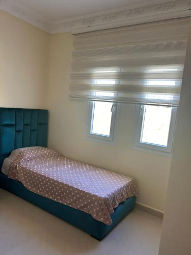 a bedroom with a bed and two windows at Achakar complexe payasage del costa in Jbila