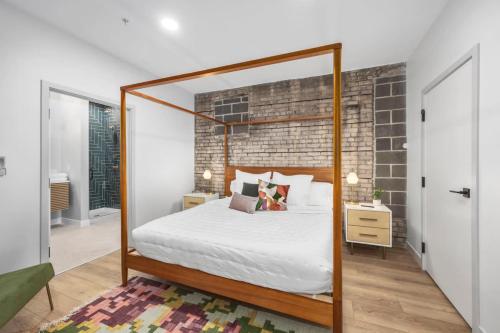 a bedroom with a bed and a brick wall at Centrally located private king suite in Grand Rapids