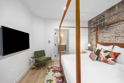 a bedroom with a bed and a tv on a wall at Centrally located private king suite in Grand Rapids