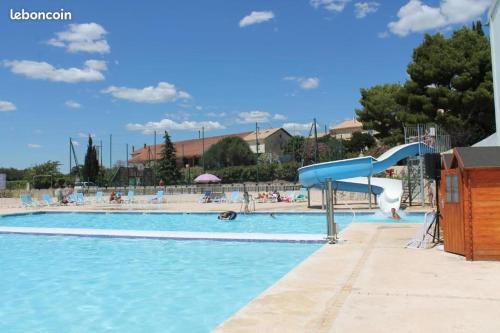 une grande piscine avec un toboggan bleu. dans l'établissement Appartement Location saisonnière Résidence ILE D'OR, à La Londe-les-Maures