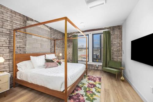 a bedroom with a canopy bed and a tv at BlueJay Hotel in Grand Rapids