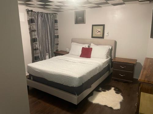 um quarto com uma cama com lençóis brancos e almofadas vermelhas em Havre de paix em Laval