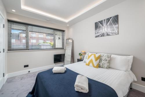 ein Schlafzimmer mit einem großen Bett und einem Fenster in der Unterkunft Skyvillion - COZY LARGE 4 & 1 Bed Apartments in London Enfield, Mins to Tube Station, Free Wi-Fi in Cockfosters