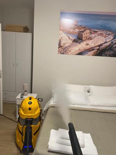 żółty kask siedzący na łóżku w sypialni w obiekcie B&B Ercole Agrigento w mieście Villaggio Mosè
