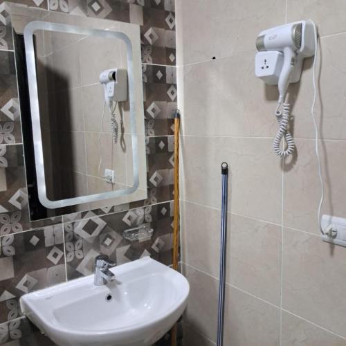 a bathroom with a sink and a mirror at استديو فندقى مكيف بتراس اكوا فيو Aquaview in El Alamein