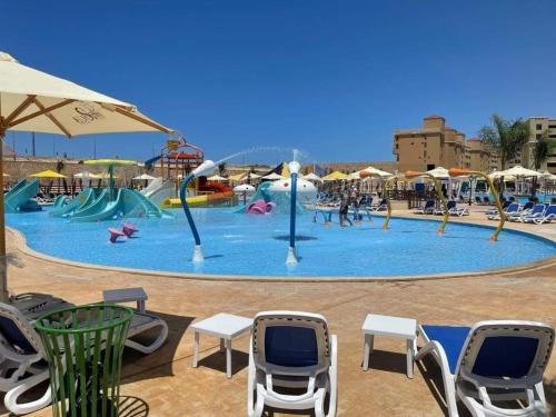 a large water park with chairs and an umbrella at استديو فندقى مكيف بتراس اكوا فيو Aquaview in El Alamein