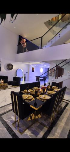 a dining room with a long table and chairs at Al MULHIM VILLA إستراحة الملهم in Rumays