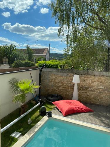une petite piscine avec un oreiller rouge et une lampe dans l'établissement Maison avec piscine sur la route des vins, à Perrigny-lès-Dijon