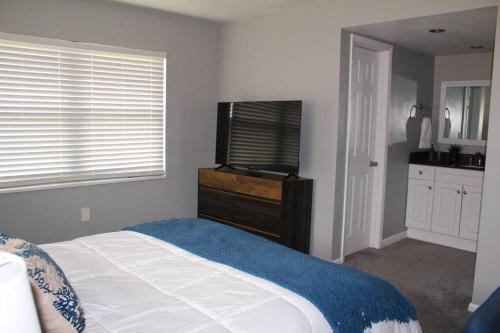 a bedroom with a bed and a flat screen tv at Rotonda Pool Oasis Near Beaches - Sleeps 9 in Rotonda West