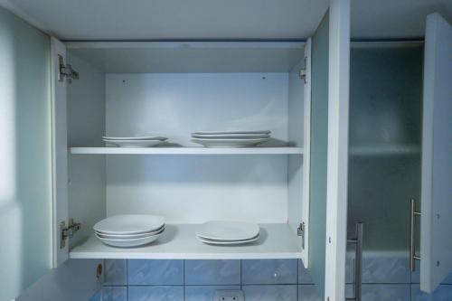 a white cabinet with plates and bowls in it at A COZY APARTMENT IN CENTRAL CUSCO in Cusco