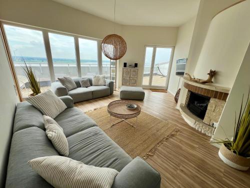 ein Wohnzimmer mit einem großen Sofa und einem Kamin in der Unterkunft COAST HOUSE Sky Suite in Bremerhaven