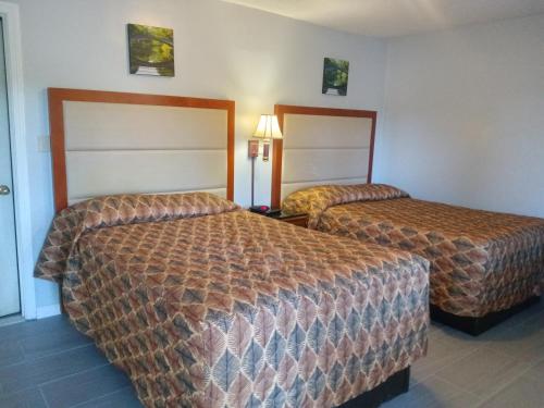 una habitación de hotel con 2 camas en una habitación en Maple leaf motel, en New Milford