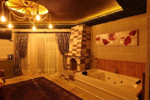 a bathroom with a large tub and a fireplace at Ashab-I Kehf Cappadocia House in Nevsehir