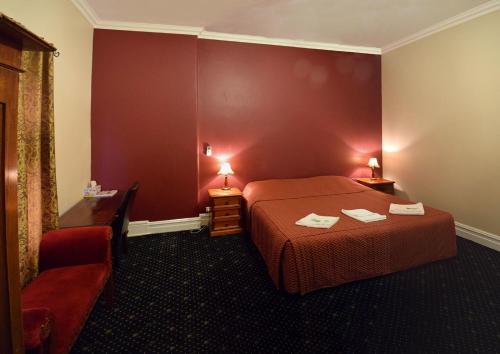 A bed or beds in a room at The Palace Hotel Kalgoorlie