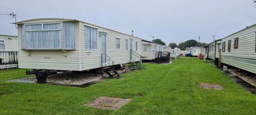 a row of mobile homes parked in a yard at Peaces caravan 8 berth on coral beach in Ingoldmells